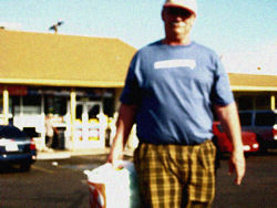 Dr. Malamud outside
his neighborhood
convenience store
with his beer cleverly
concealed behind white
plastic bags