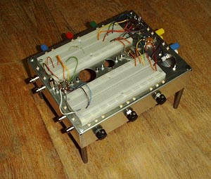 Top view of breadboarding chassis.  Two IC style breadboarding sockets are mounted parallel to each other with space between.  Holes for tube sockets have been  punched and drilled between the sockets.  More sockets can be mounted at the right end of the B B sockets.  Three pots are mounted on the front and binding posts, phono jacks and B N C connectors are mounted around the other sides of the chassis.