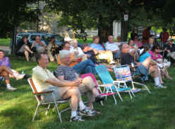 Concert goers under the trees on the seminary lawn