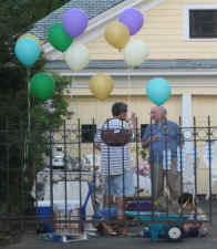 Stragglers enjoy the party as colorful balloons float above