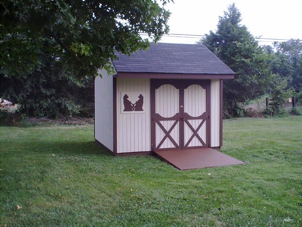 Photo showing finished shed.  Sue painted a decoration of two cats with their tails intertwined.  Everybody who sees it says That's cute.