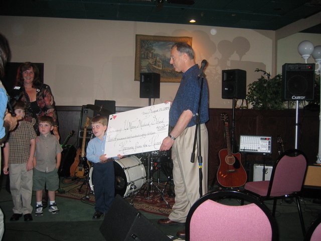 Toby presenting check to Dr. Michelson